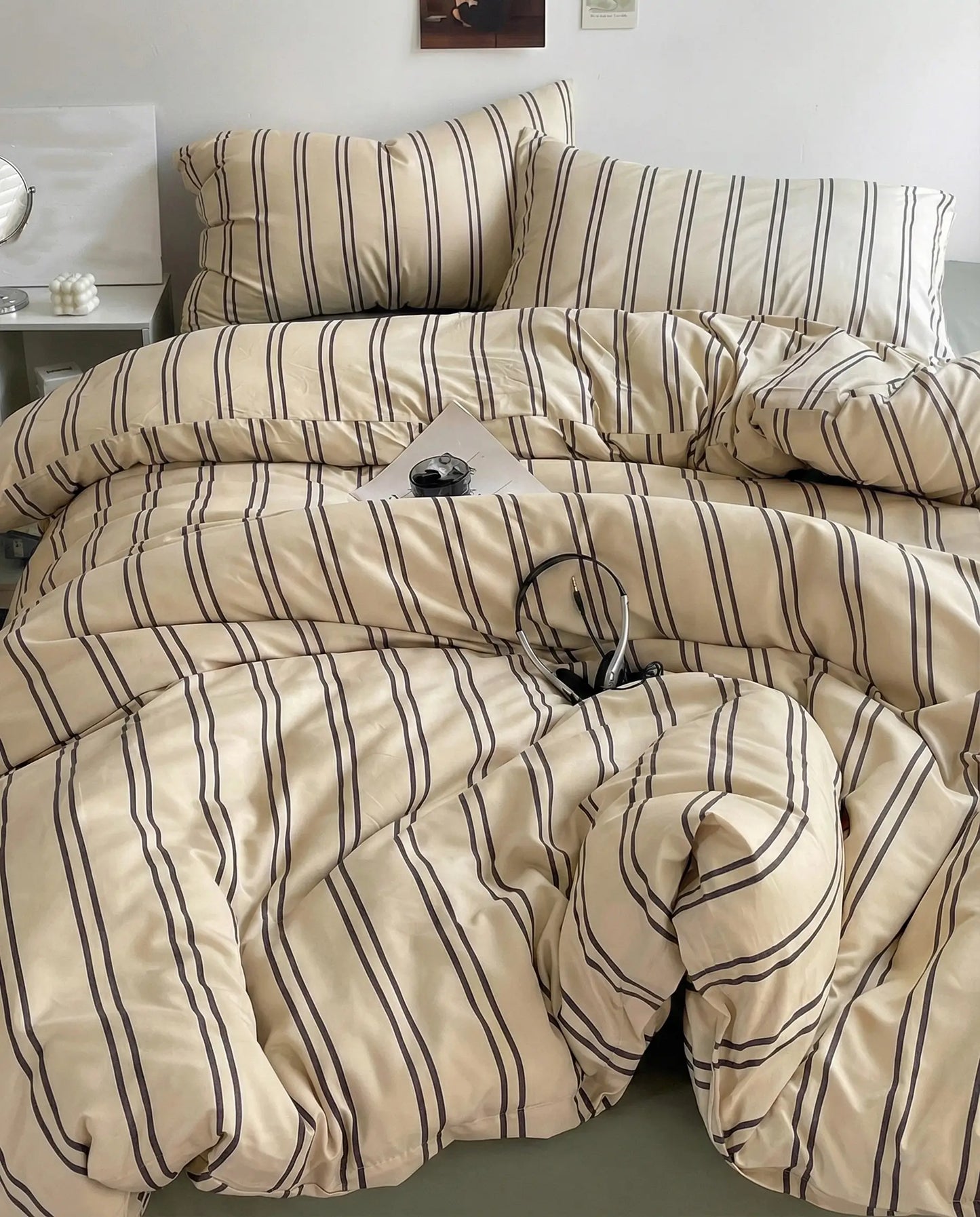 Minimal striped bedding set with beige and dark pinstripes styled in cozy neutral bedroom