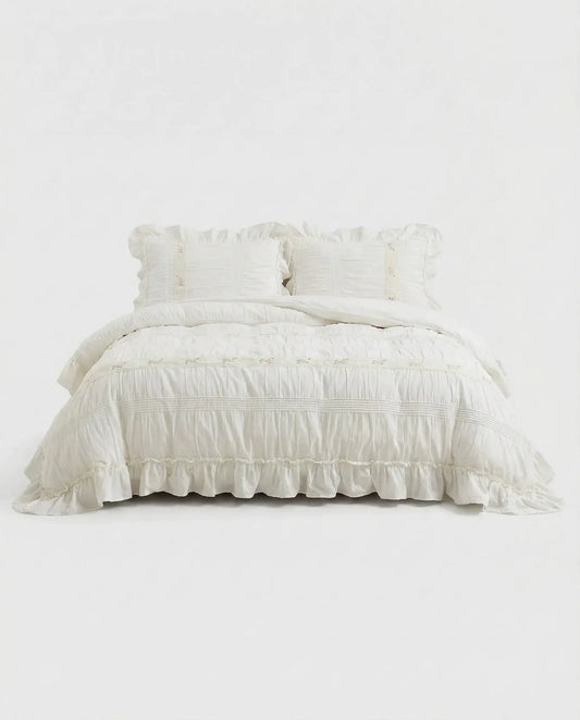 White ruched duvet cover set studio image showing ruffled hem, textured fabric, and matching pillow shams