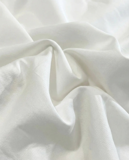 White cotton duvet cover fabric close up showing smooth weave and soft luxury bedding texture