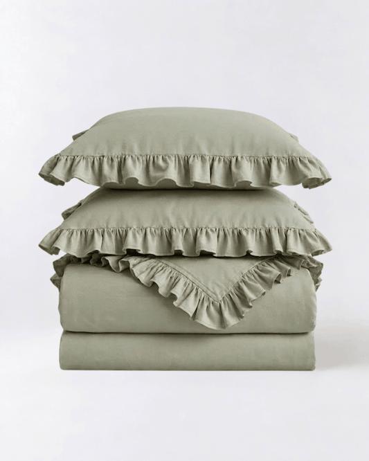Folded eucalyptus sage ruffle bedding set showcasing soft washed cotton fabric and elegant layered ruffle detailing by DORMÉ Studio