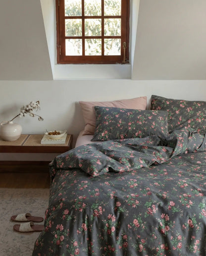 Black floral duvet cover set styled on bed with pink pillows and wooden nightstand, modern romantic bedroom decor