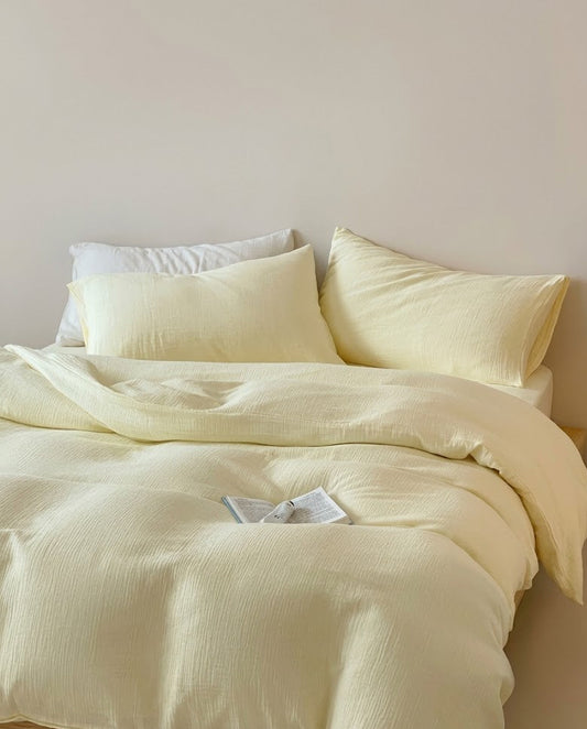 Butter muslin cotton double gauze duvet cover and pillowcases on a bed with a white pillow and open book