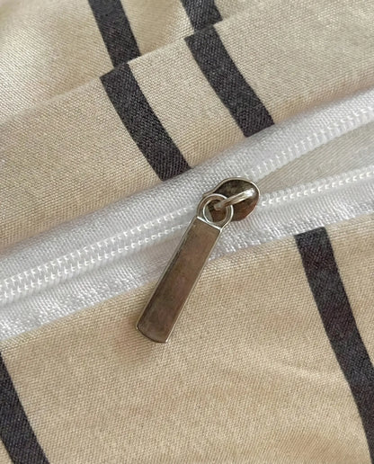 Close up of beige striped duvet cover with hidden zipper closure and soft woven cotton texture
