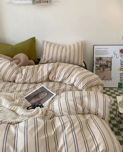 Neutral striped duvet cover with matching pillowcases styled with soft decor in calm aesthetic bedroom