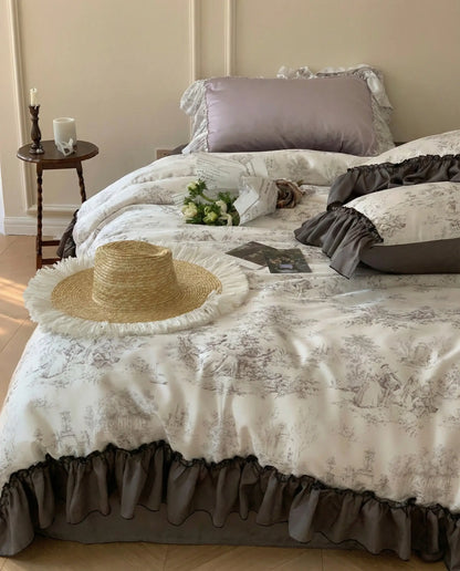 Close up of toile patterned duvet and ruffled pillow shams styled with flowers, romantic vintage bedding set