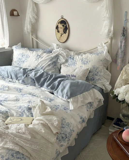 Blue floral duvet cover with soft ivory base and romantic ruffle trim styled in vintage cottage bedroom