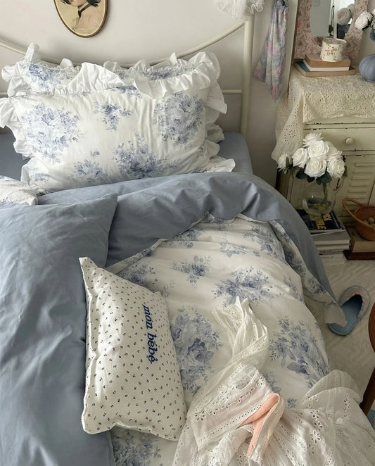 Blue floral duvet cover with airy ruffle detailing styled on white metal bed frame