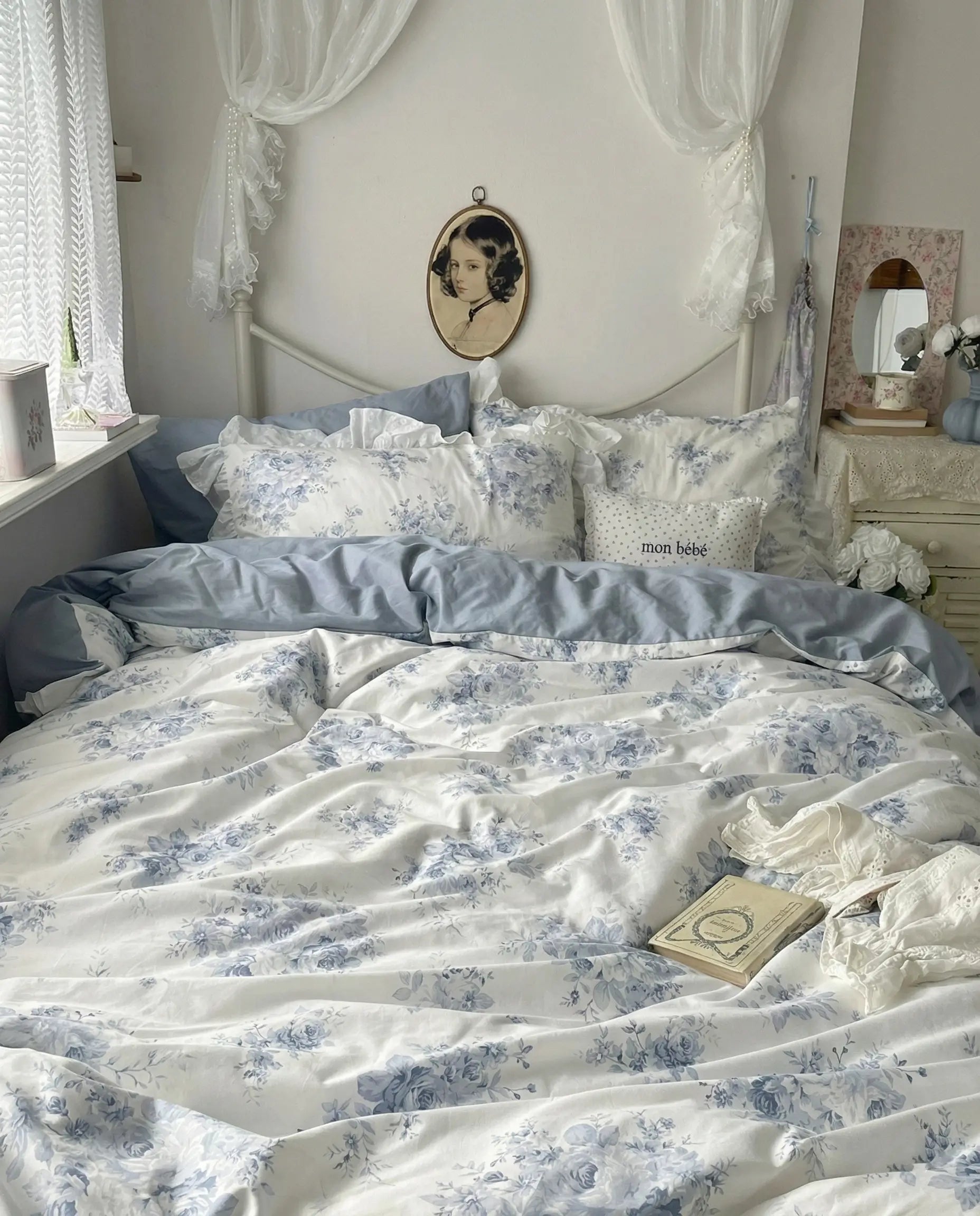 Ruffled blue floral bedding set with matching pillowcases and delicate lace details in cozy bedroom