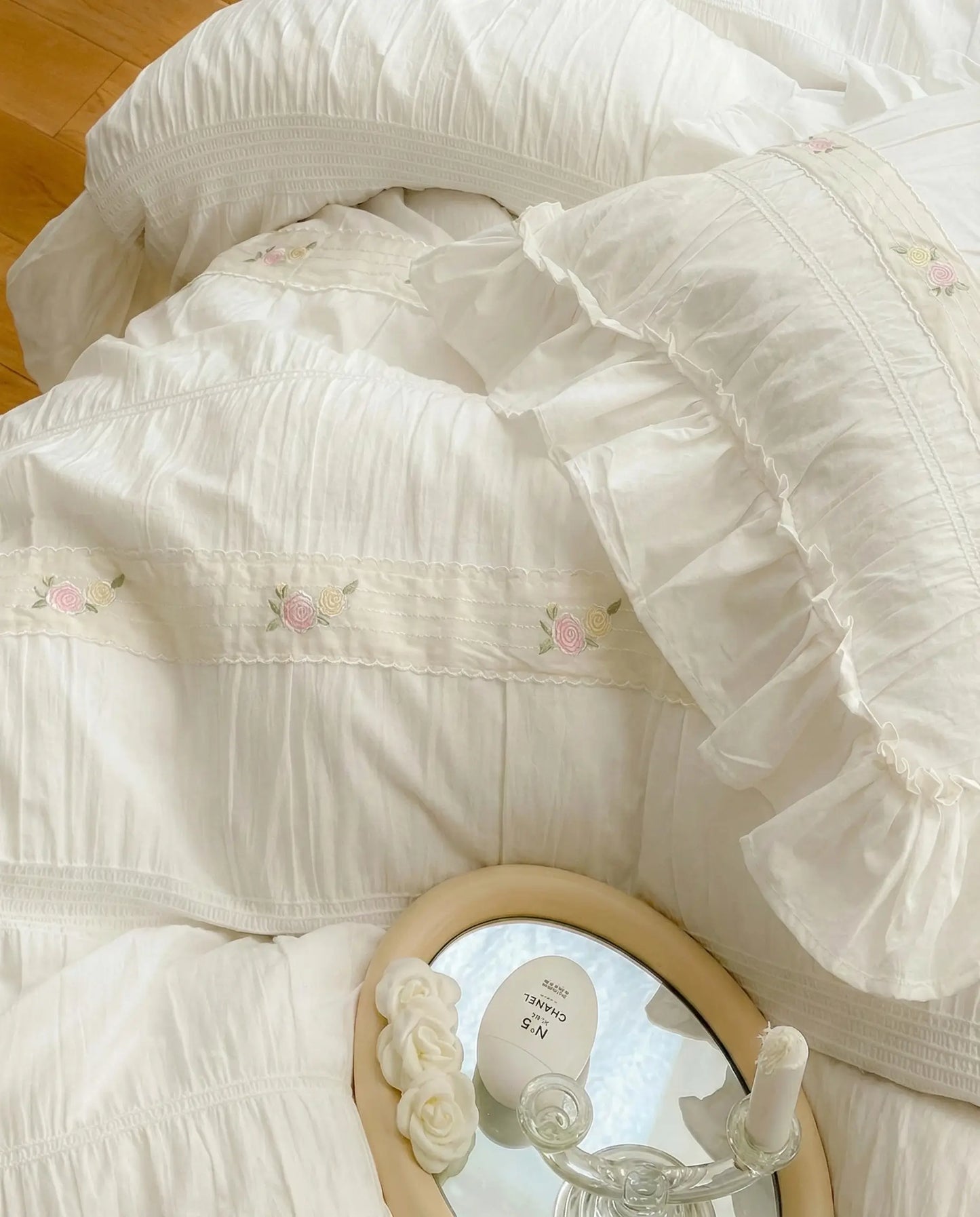 Close up of white ruched duvet cover with subtle floral embroidery and gathered stitched detailing