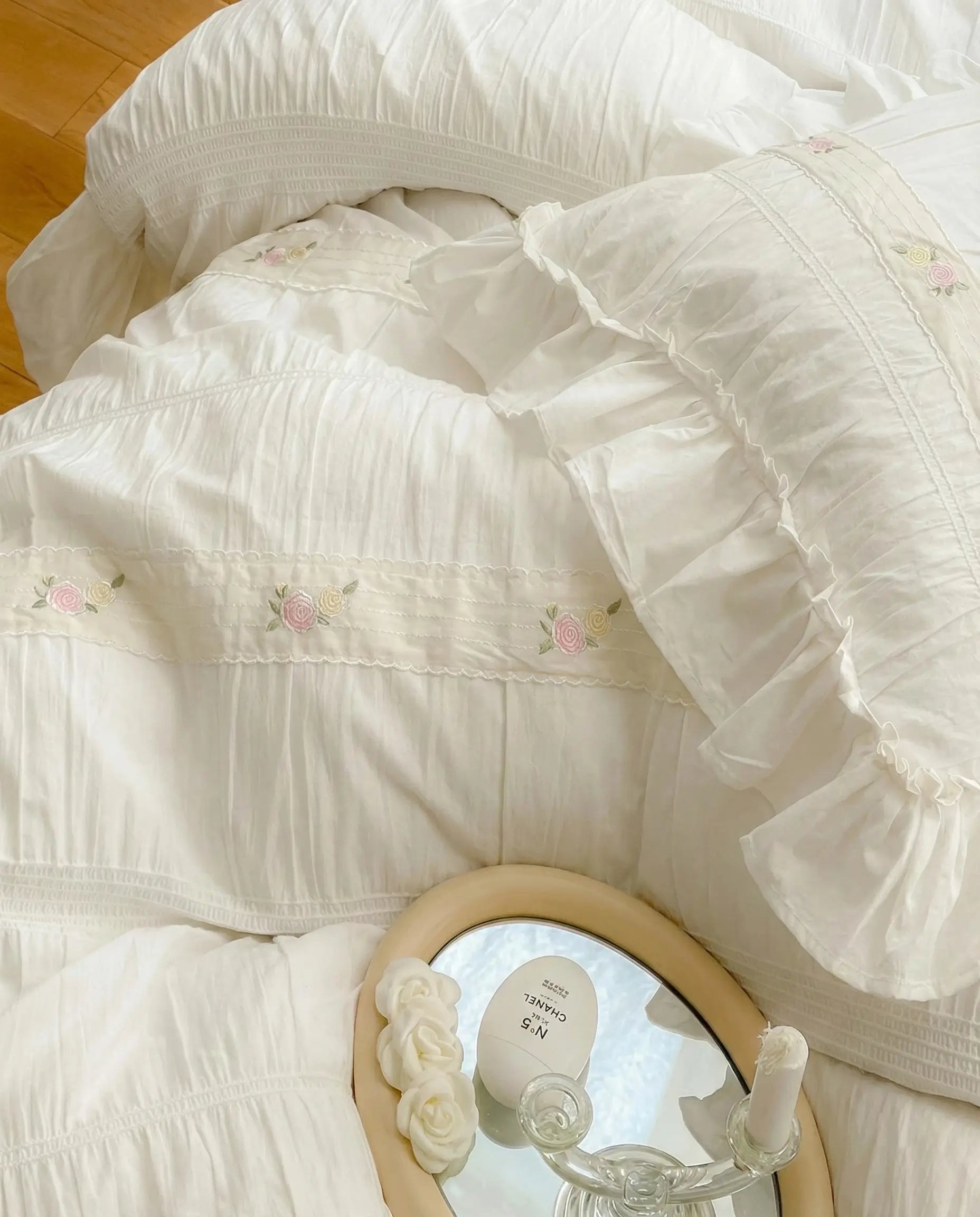 Close up of white ruched duvet cover with subtle floral embroidery and gathered stitched detailing