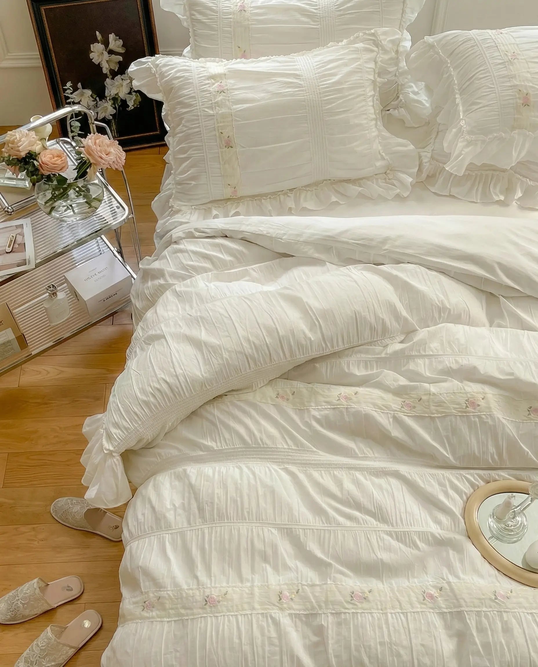 White ruched duvet cover set styled with tray and candles on bed in classic white bedroom