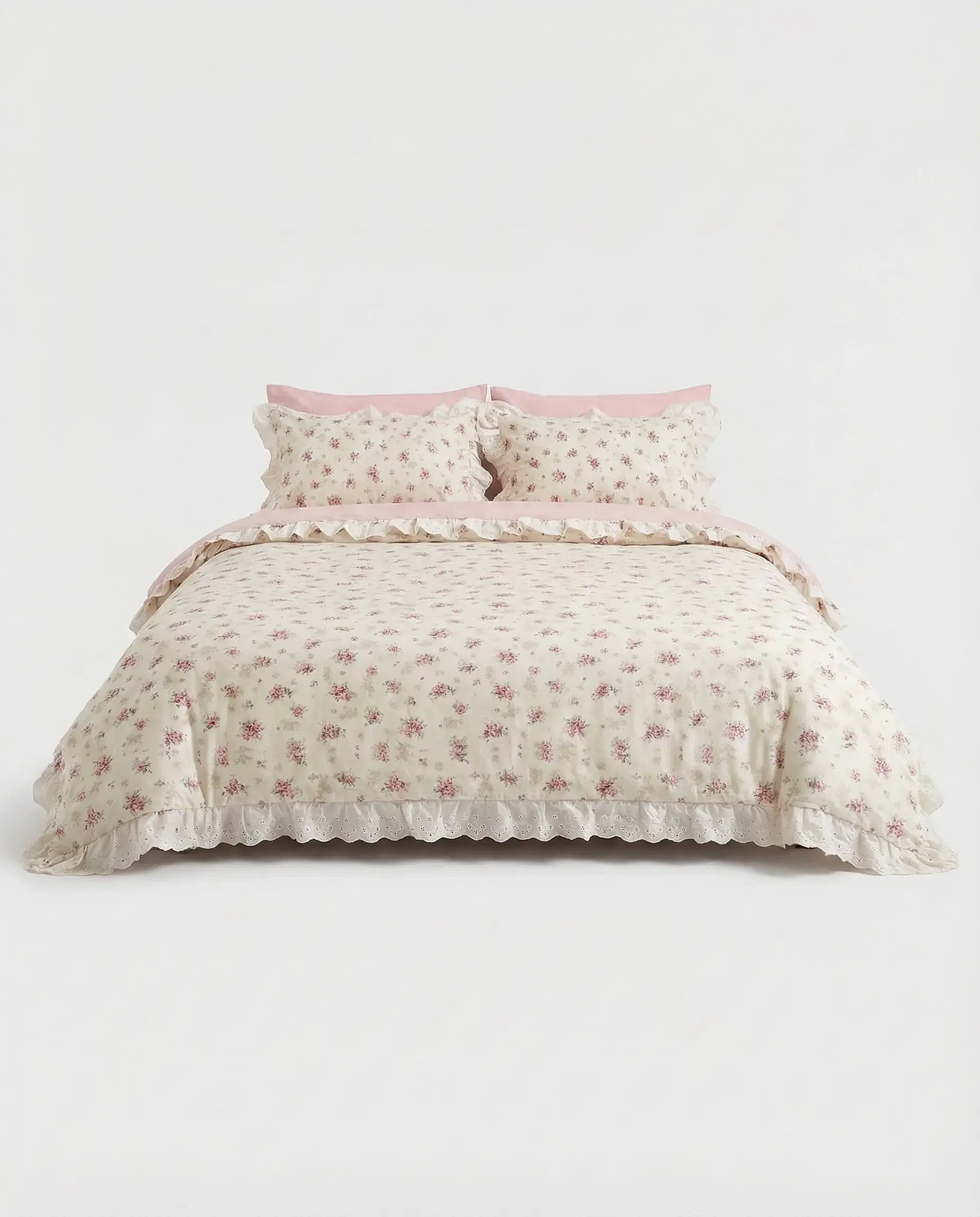 Vintage floral duvet cover set with lace trim and blush pink pillowcases on clean white studio bed