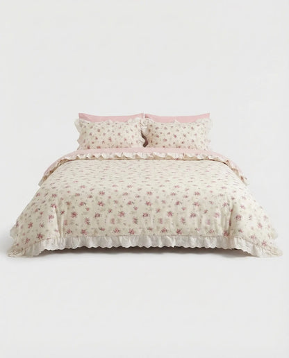 Vintage floral duvet cover set with lace trim and blush pink pillowcases on clean white studio bed