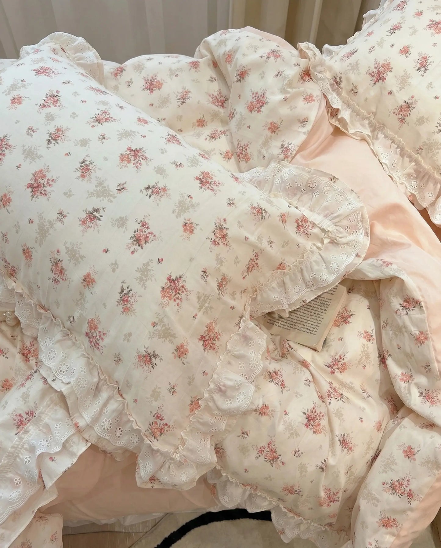 Soft ivory floral duvet cover with pink rose print and lace ruffle trim in romantic cottagecore bedroom setting