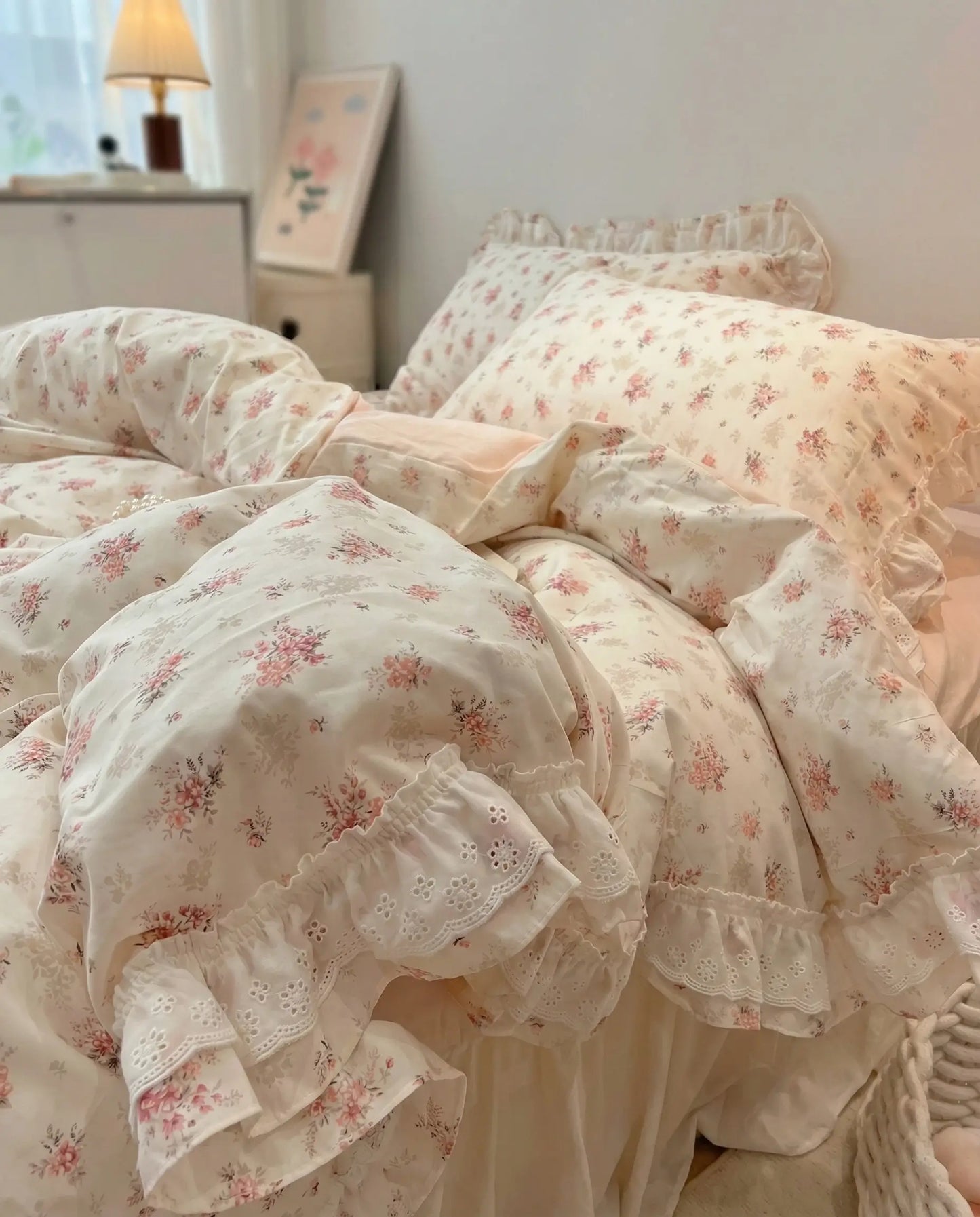 Vintage floral bedding set with ruffled pillowcases and blush pink sheets in cozy feminine bedroom decor