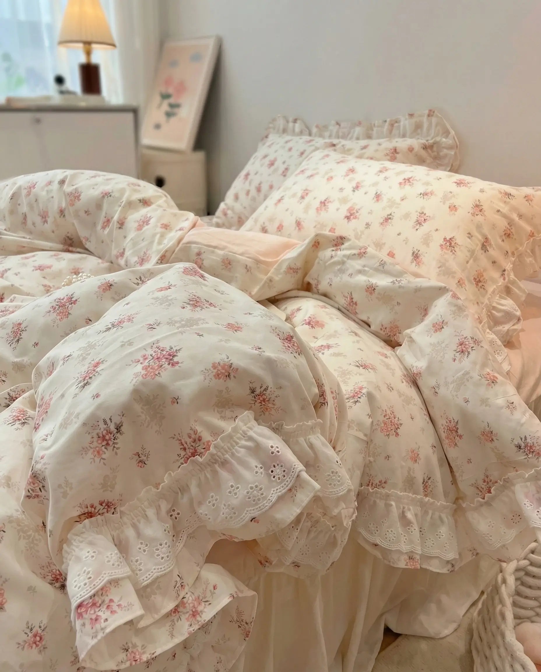 Vintage floral bedding set with ruffled pillowcases and blush pink sheets in cozy feminine bedroom decor