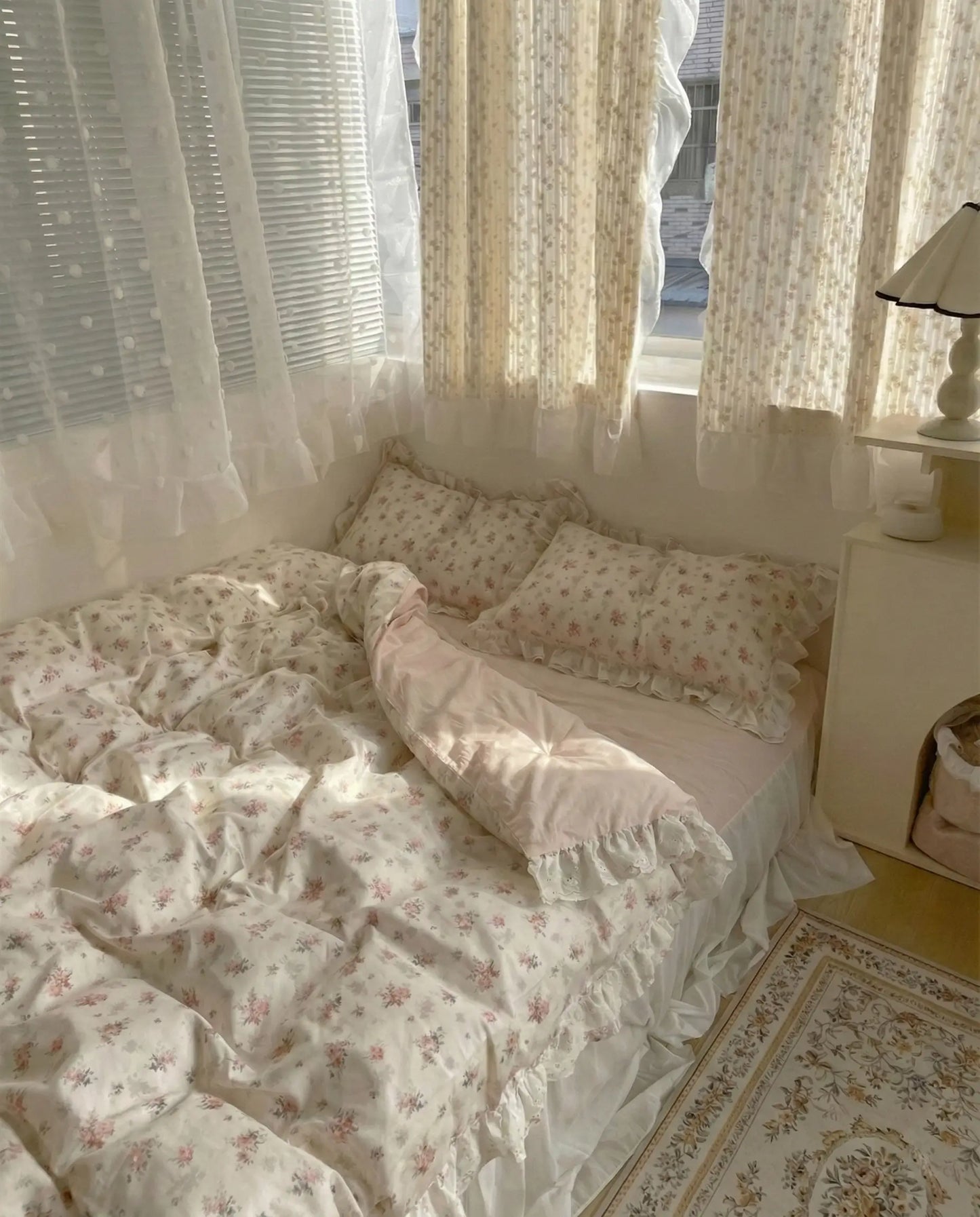 Elegant floral bedding set with ruffled pillows and sheer bed skirt in light vintage inspired room