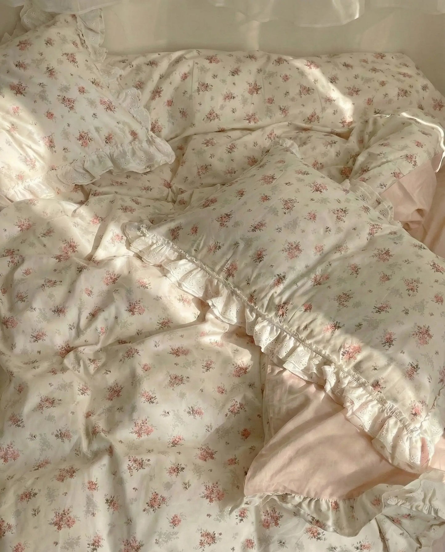 Cottage style floral duvet cover with soft blush sheets and romantic lace trim in bright bedroom