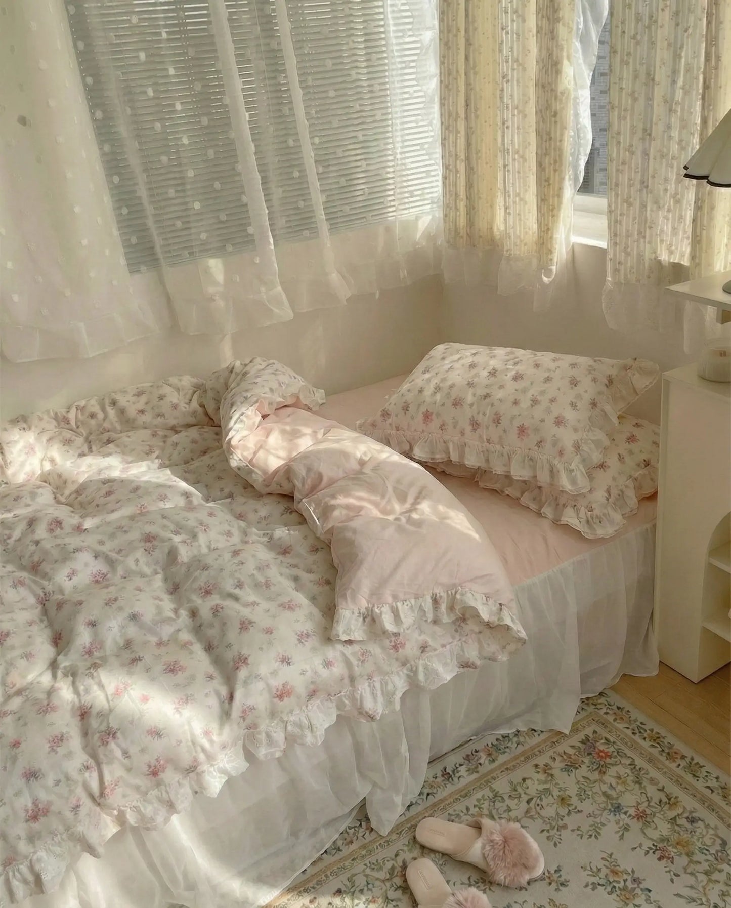 Delicate floral bedding set with frilled pillowcases and pastel pink accents in airy aesthetic room