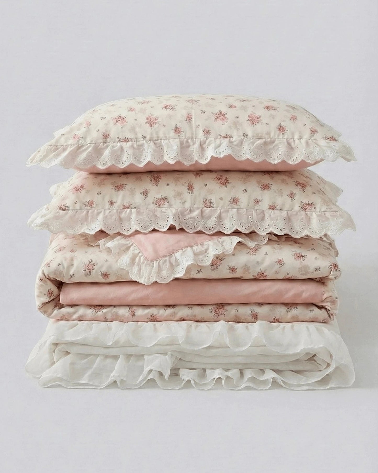 Floral duvet cover set with lace ruffle trim and blush pink sheets folded studio style product photo
