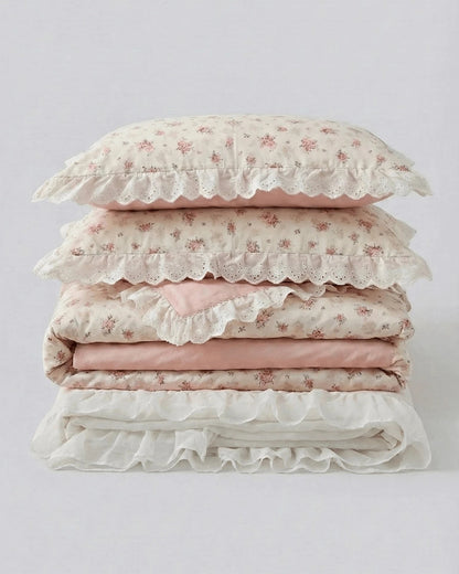 Floral duvet cover set with lace ruffle trim and blush pink sheets folded studio style product photo