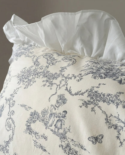 Close-up of grey toile floral fabric with sheer ruffled trim on a white duvet cover, highlighting vintage pattern and soft woven texture, aesthetic bedding, vintage bedding, floral duvet, white bedding, grey floral, romantic bedroom, cottage bedroom, bedroom decor
