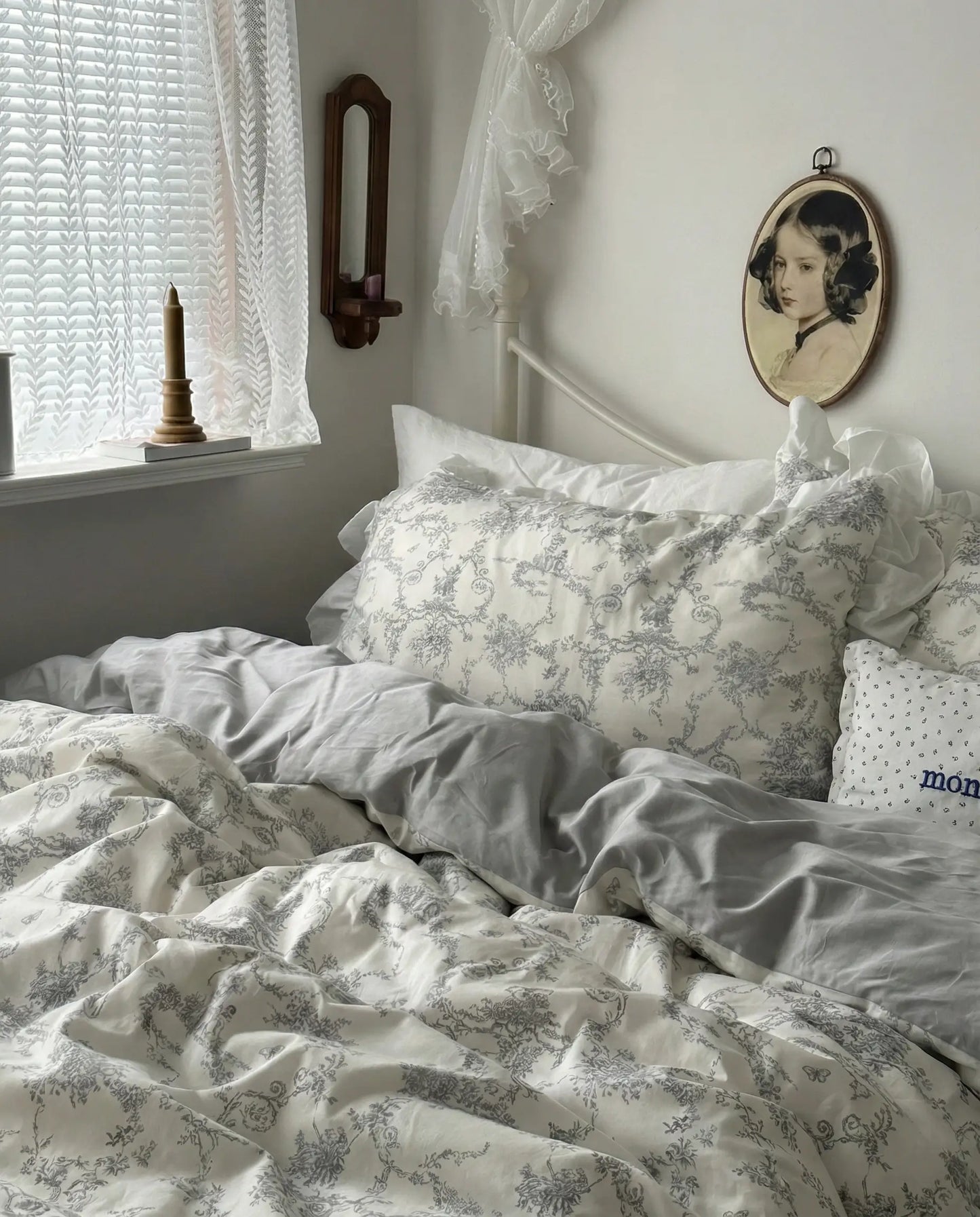 Vintage floral duvet cover set styled on a white metal bed near a window, featuring soft grey toile pattern and relaxed ruffled bedding, aesthetic bedroom, vintage bedding, floral duvet, white bedding, grey floral, romantic bedroom, cottage bedroom, bedroom decor