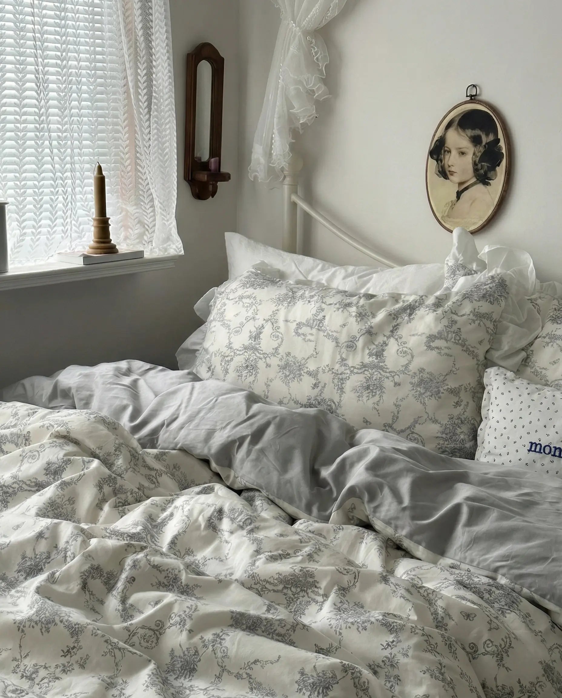 Vintage floral duvet cover set styled on a white metal bed near a window, featuring soft grey toile pattern and relaxed ruffled bedding, aesthetic bedroom, vintage bedding, floral duvet, white bedding, grey floral, romantic bedroom, cottage bedroom, bedroom decor