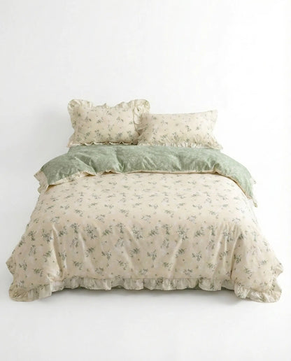 Studio image of floral bedding set with sage green botanical print and ruffled trim