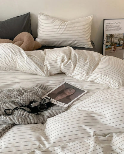 Pinstripe duvet cover styled in a cozy bedroom with neutral decor, soft lighting, and relaxed folds for an effortless lived-in aesthetic.