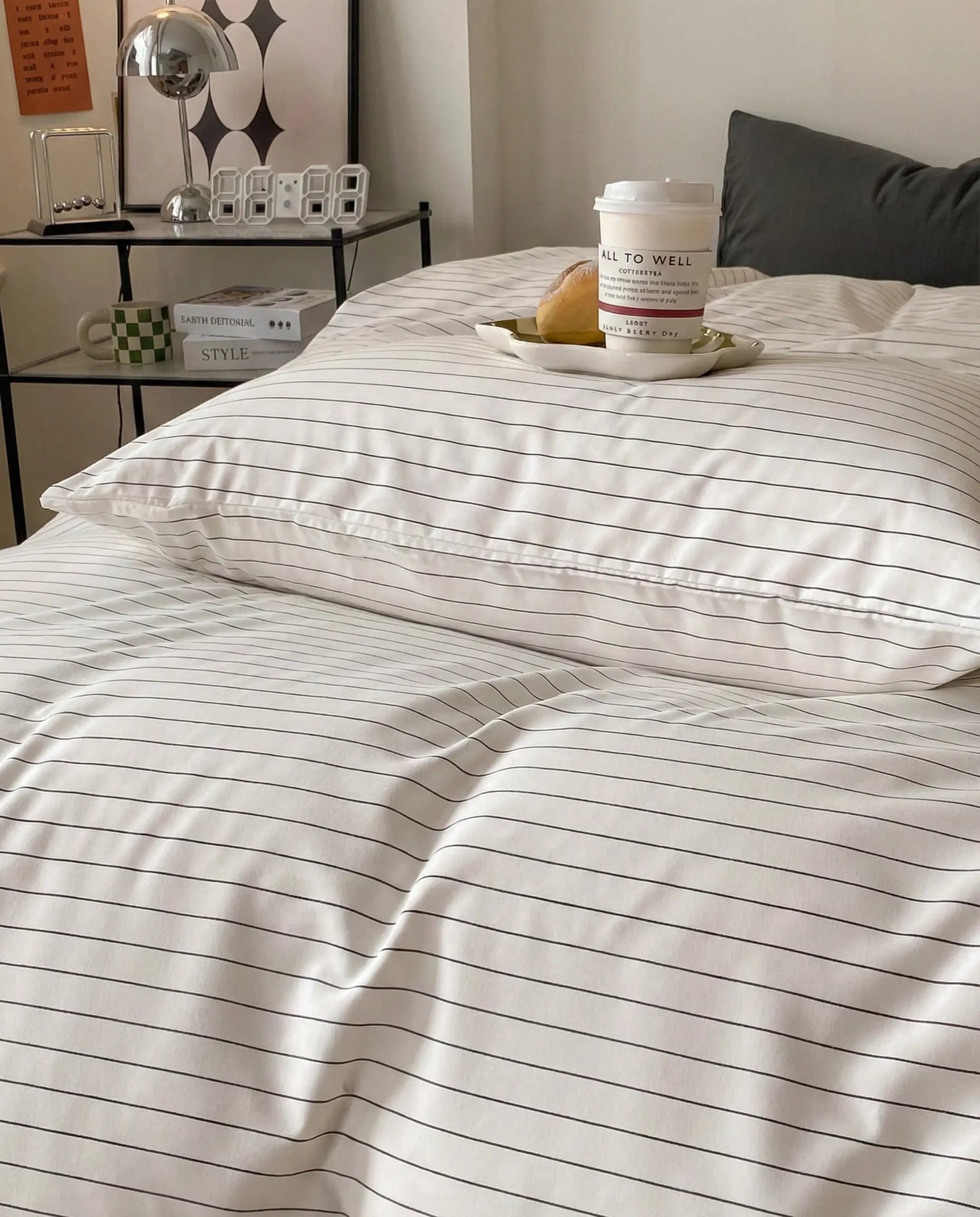 Striped pillowcase and duvet detail featuring thin black pinstripes on white fabric with a smooth finish and clean tailored edges.