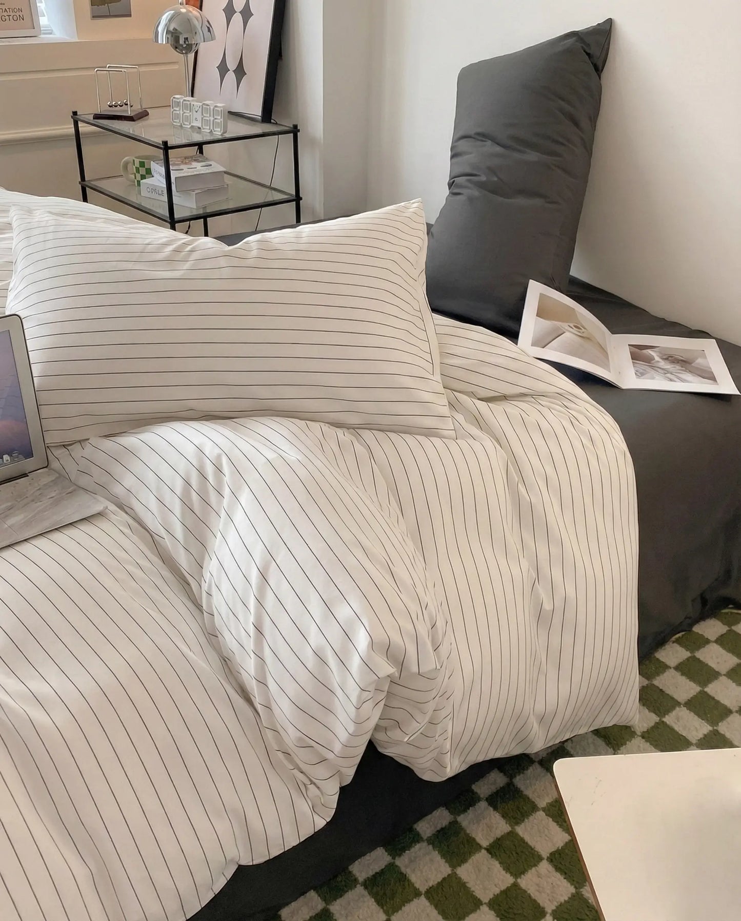 Striped duvet and pillowcase styled beside a modern nightstand with decor accents, creating a warm and contemporary sleep space.