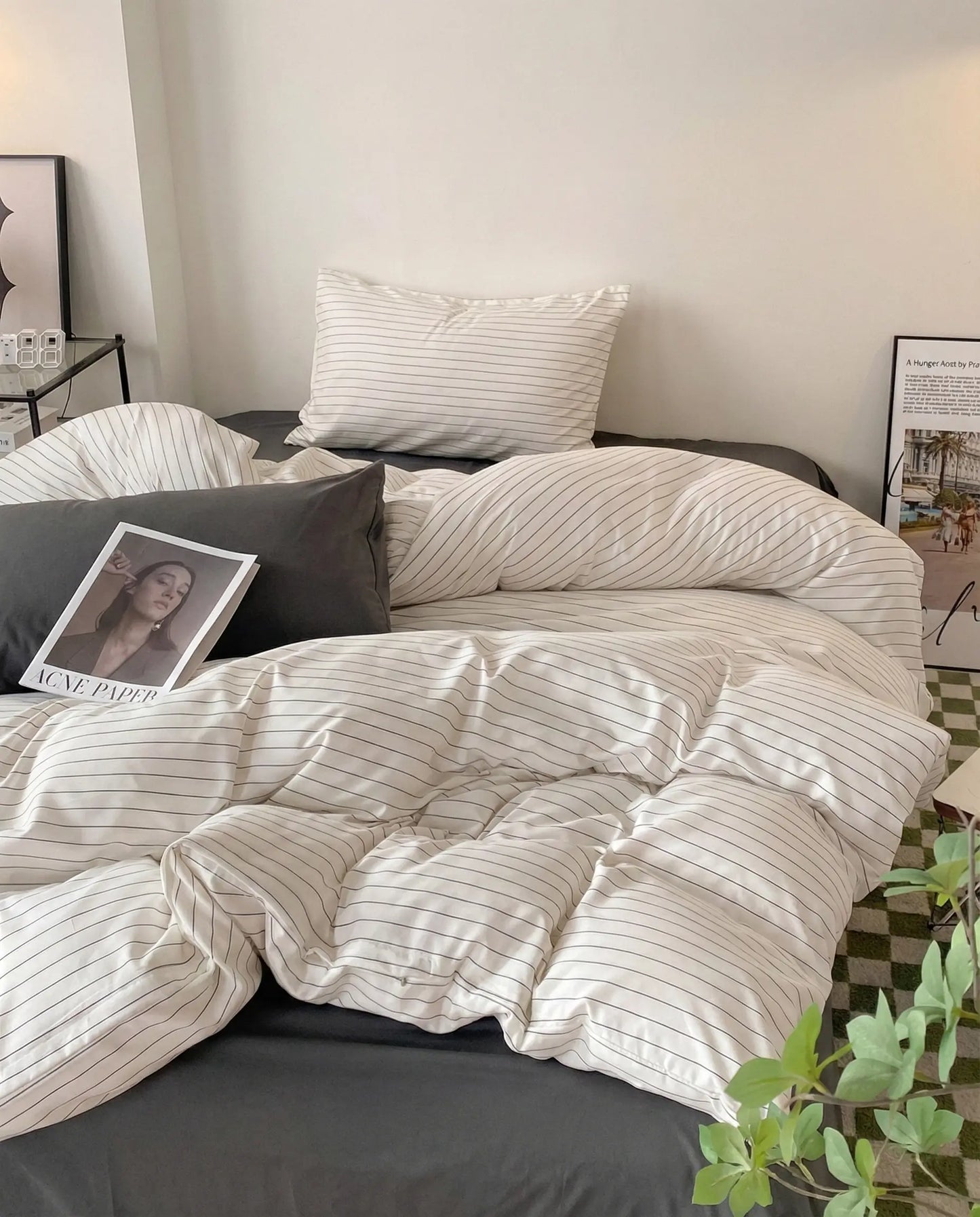 Modern striped duvet cover styled on a bed with charcoal sheets, neutral pillows, and soft layered textures in a calm, contemporary bedroom.