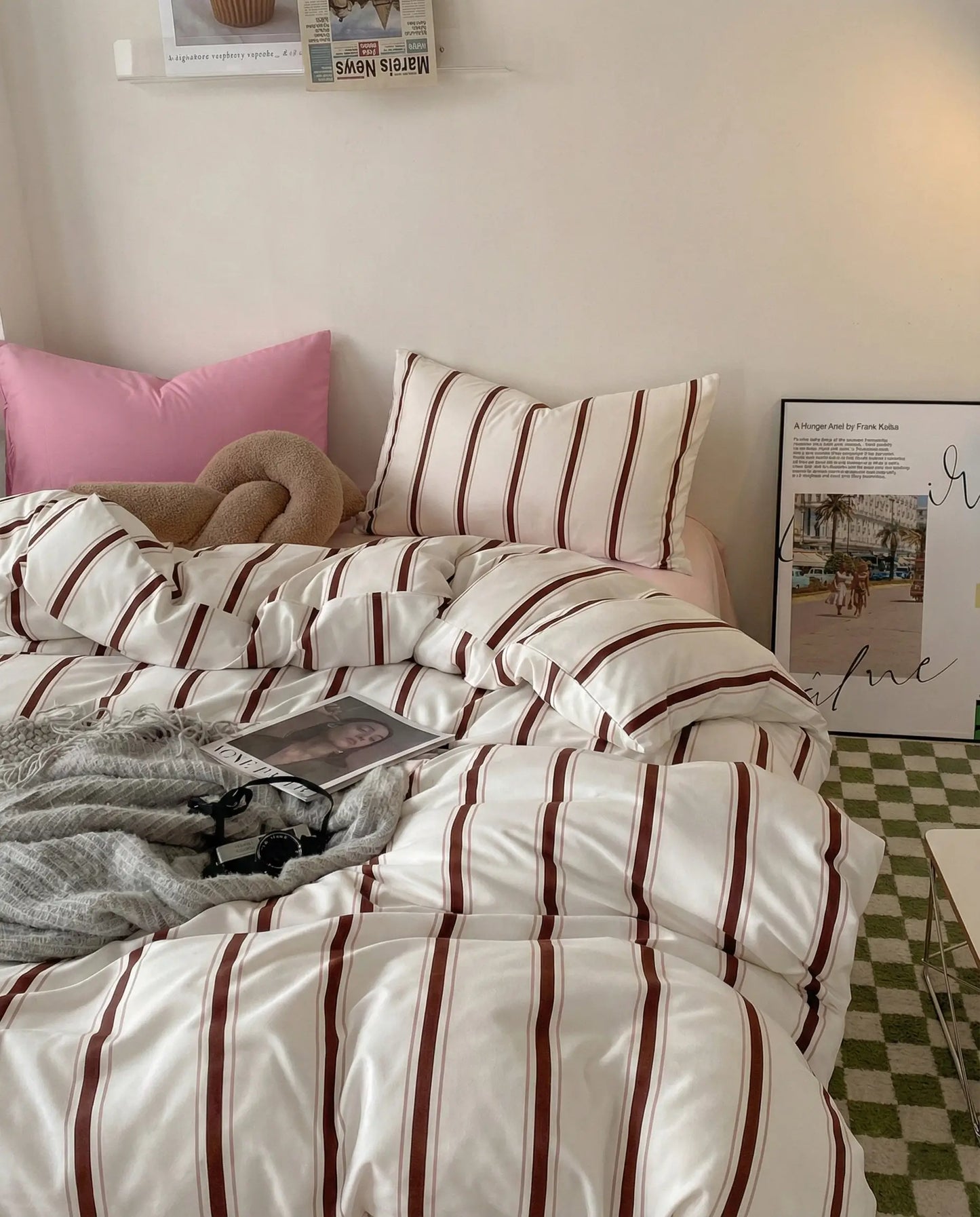 Striped duvet cover set layered over blush pink fitted sheet, styled with neutral bedroom decor and framed wall art