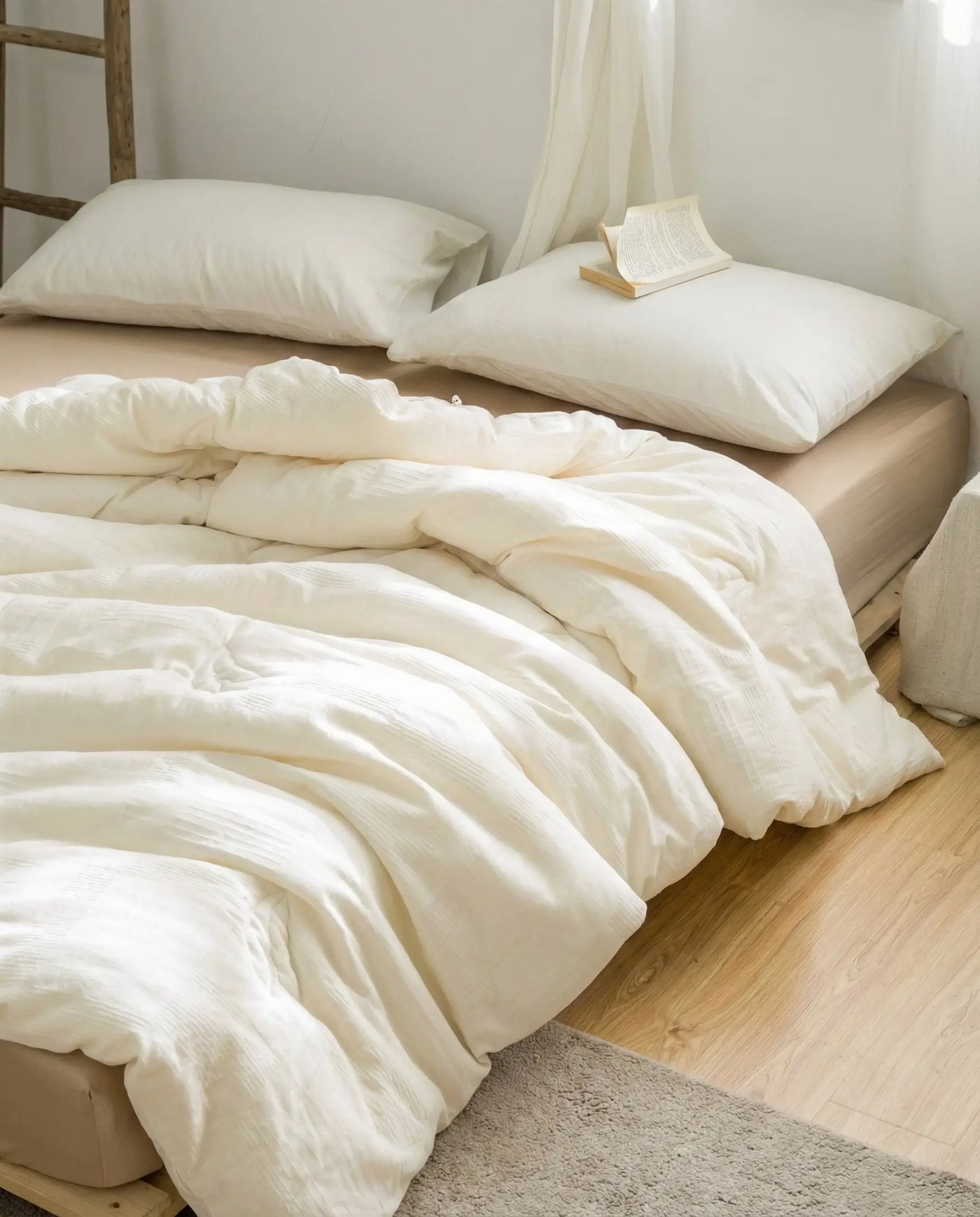 A neatly made bed dressed in a DORMÉ duvet cover over the soybean-fiber insert, in a calm neutral room