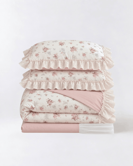 Floral duvet cover set with lace ruffle trim and blush pink sheets folded studio style product photo