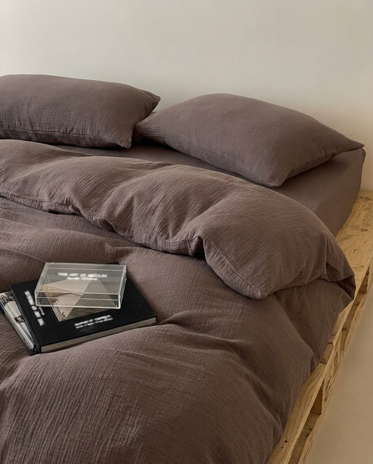 Relaxed Espresso muslin cotton double gauze duvet cover and pillowcases with stacked books