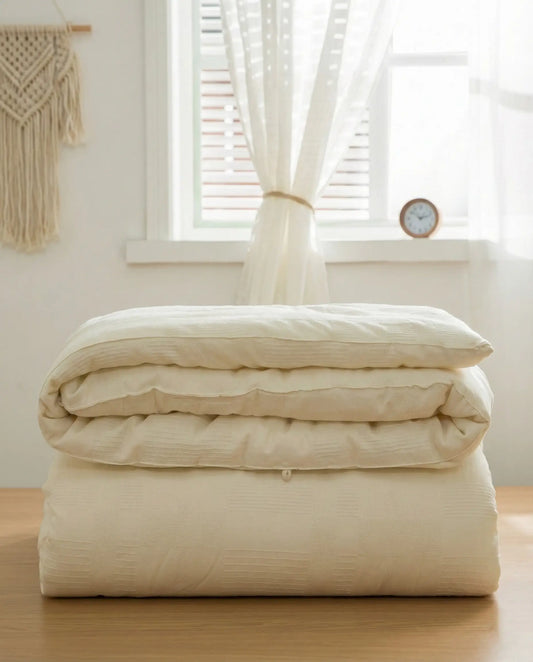 Folded organic soybean fiber duvet insert showing breathable cotton shell texture, hypoallergenic luxury duvet insert by DORMÉ Studio.