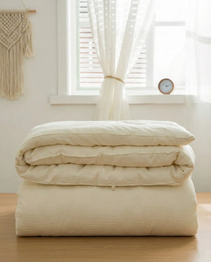 Folded organic soybean fiber duvet insert showing breathable cotton shell texture, hypoallergenic luxury duvet insert by DORMÉ Studio.