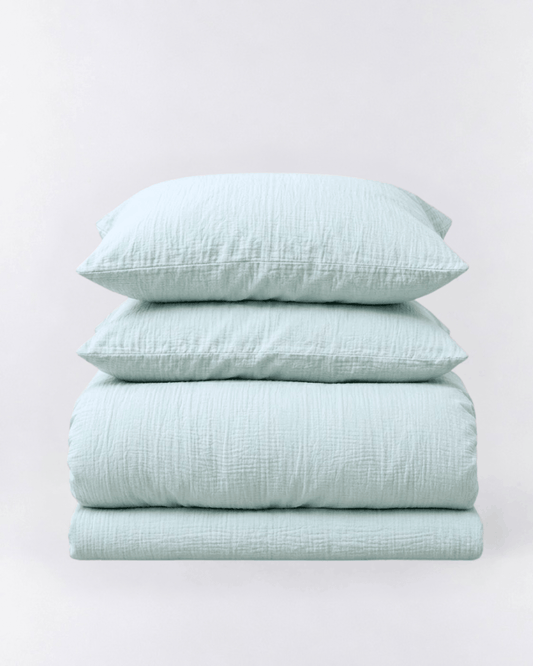 Amalfi Muslin Cotton Duvet Cover Set in Seafoam, folded duvet cover and two pillowcases on light grey