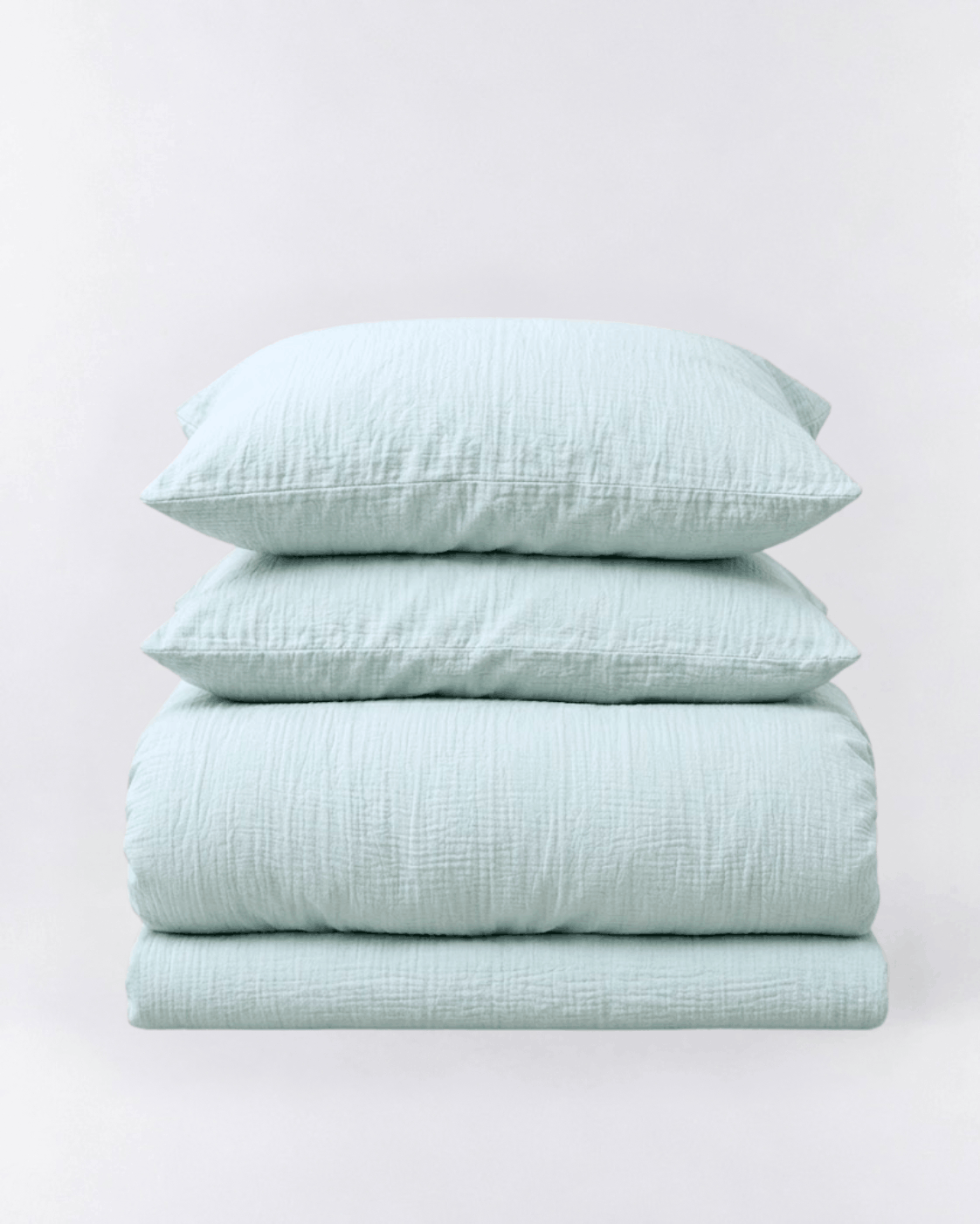Amalfi Muslin Cotton Duvet Cover Set in Seafoam, folded duvet cover and two pillowcases on light grey