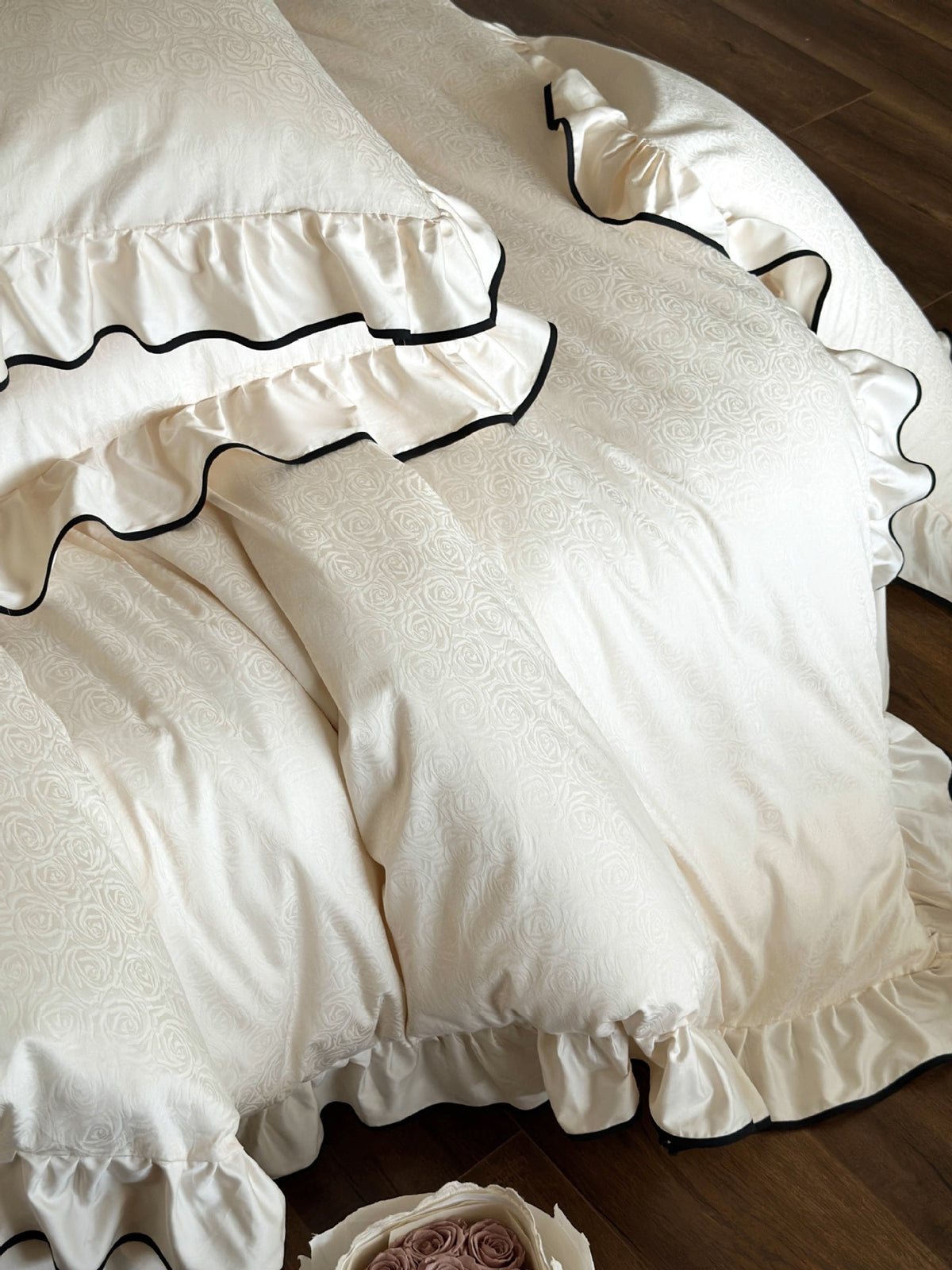Rose jacquard fabric detail on the Camellia Ruffled Duvet Cover Set in Ivory with ruffled black piped edges