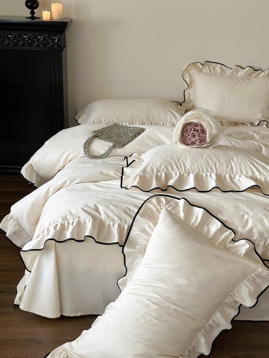 Camellia Ruffled Duvet Cover Set in Ivory with rose jacquard pattern, ruffled shams and black piping trim