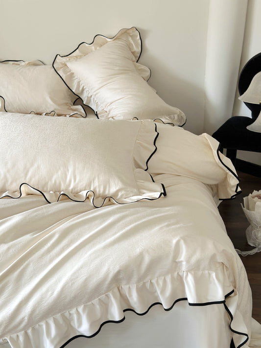 Ivory rose jacquard pillow shams with black piped ruffles from the Camellia Ruffled Duvet Cover Set