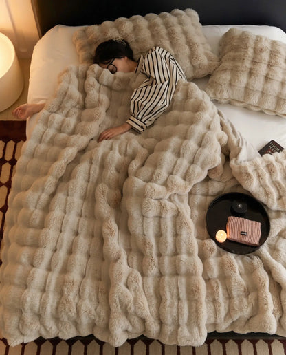 Woman sleeping under DORMÉ Studio Marshmallow Ultra Plush Blanket in khaki plush fabric styled on luxury bed.