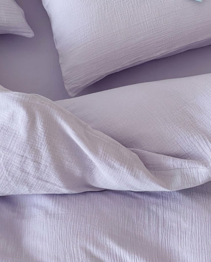 Close-up of lilac muslin cotton double gauze bedding showing the soft crinkled texture