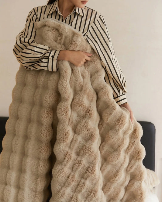 Person holding DORMÉ Studio Marshmallow Ultra Plush Blanket in khaki plush fabric showing thick sculpted texture. Khaki