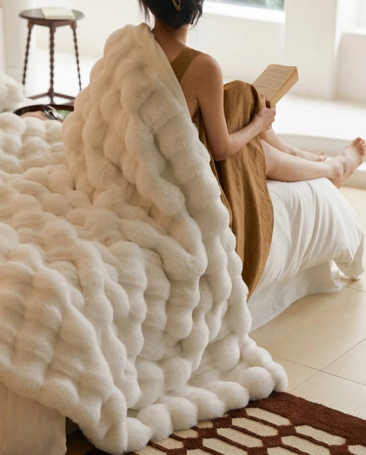 DORMÉ Studio Marshmallow Ultra Plush Blanket cuddled up on a woman, creating a warm luxury bedroom mood. White