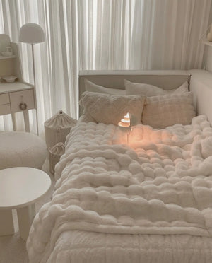 DORMÉ Studio Marshmallow Ultra Plush Blanket styled on a minimalist neutral bedroom bed with sculpted plush texture.