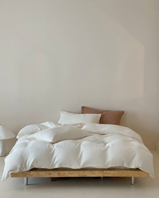 Pearl Amalfi muslin cotton duvet cover set on a low platform bed in a minimal bedroom with a paper lamp